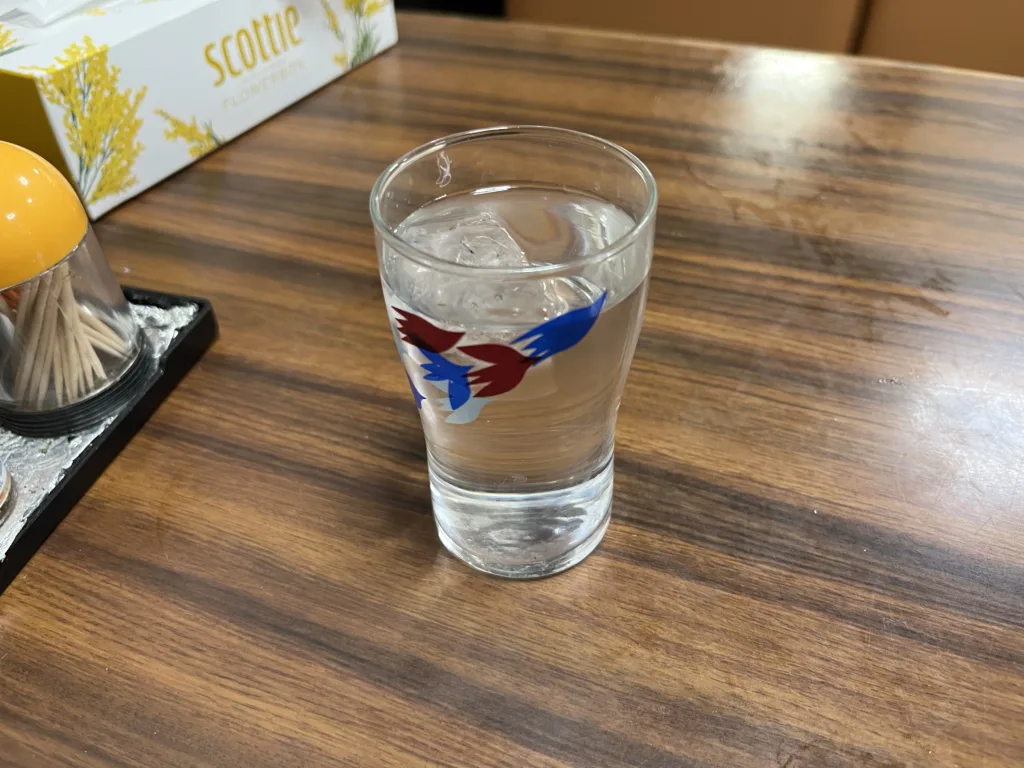 A water glass with a bird illustration