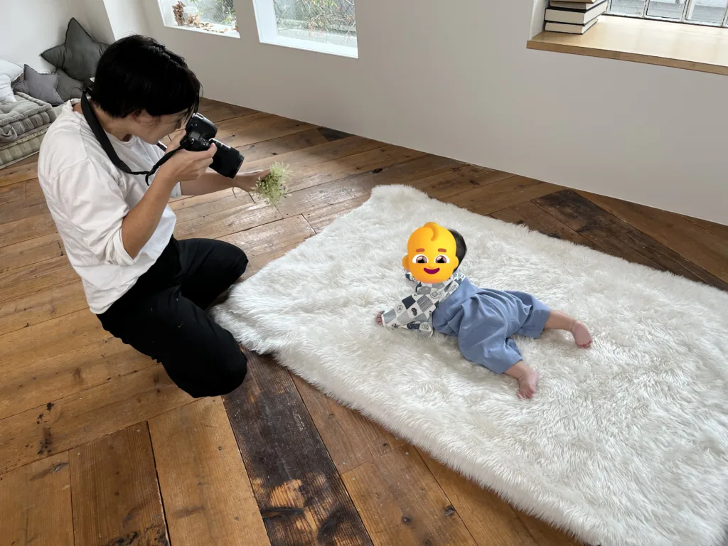 A photographer from studio Loulou is taking pictures of a baby.