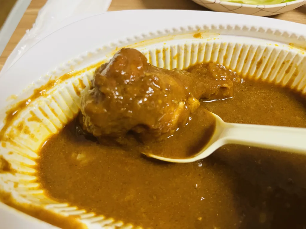 Tender chicken emerging from the curry sauce